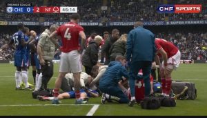 Jesse-Derry-is-treated-on-the-pitch-at-Stamford-Bridge.jpg