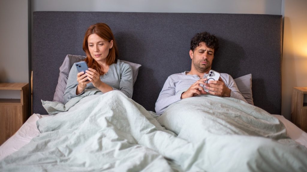 couple-in-bed-on-phones.jpg