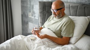 man-taking-medication-bed.jpg